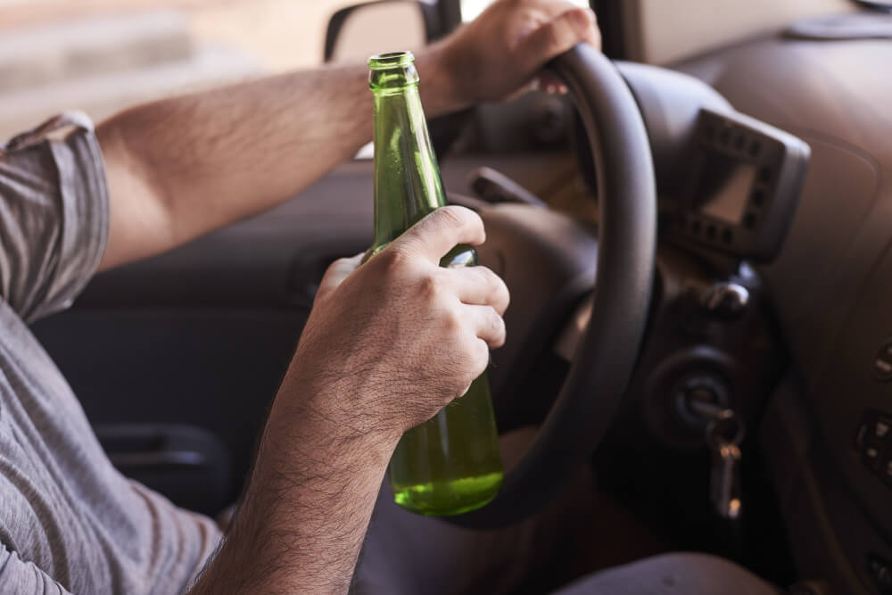 Person Driving and Holding a Beer on Their Hand